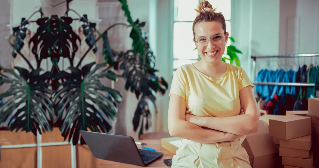 Leende ung affärskvinna på hennes kontor.